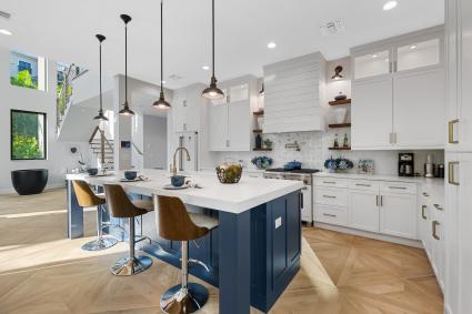 White, luxury kitchen with a blue stained island
