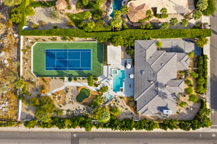 aerial view of palm springs home with pool, golf, and tennis court