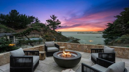 A peaceful patio, complete with chairs and a fire pit, bathed in the soft hues of a sunset