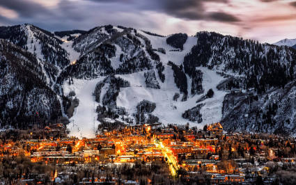 Snowy mountains stand in stark contrast to green meadows in Aspen, one of the best spring break ideas for families.