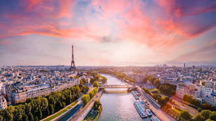 Paris skyline and Seine river with a bright pink sunset above.