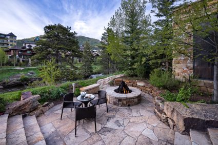 Outdoor patio with a fireplace and small table set