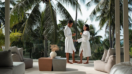 Two people in bathrobes enjoy a stay in the jungle at one of the best vacation spots for couples.