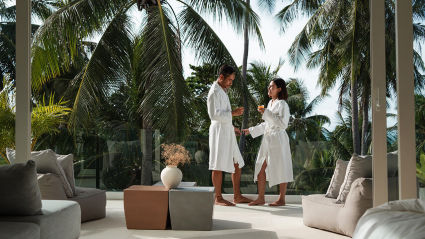 Two people in bathrobes enjoy a stay in the jungle at one of the best vacation spots for couples.