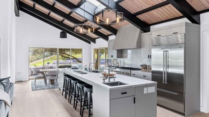 A Napa vacation home kitchen with a spacious island and rustic wooden ceiling