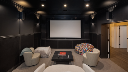 A home theater room with a large screen and black walls, perfect for an immersive movie experience