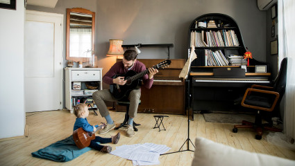 A man and his son play guitar in their music room, one of the most popular zen room ideas.