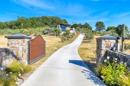 A long, gated driveway leading to a home