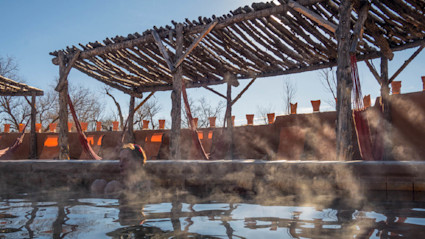 Couple relaxing in a mineral hot spring pool along the Rio Grande in New Mexico