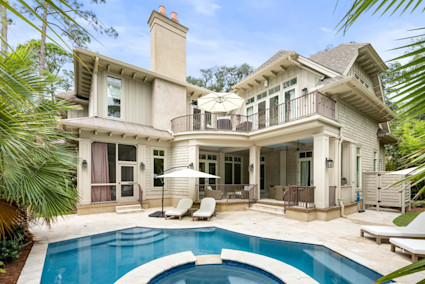 Seaside pool area with plunge pool and hot tub with covered lounge area and poolside lounge chairs.