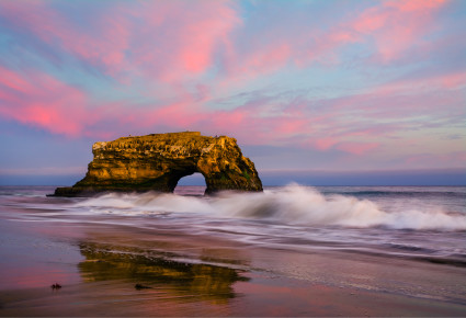 A rock archway amongst crashing ocean waves
