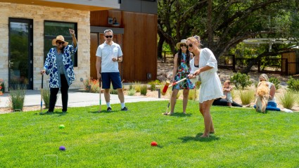 Ground of friends playing a round of croquet on their lawn