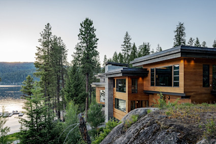 home on cliff edge overlooking lake and trees
