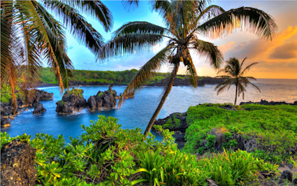 Palm trees frame Maui’s fiery shoreline sunset, creating the dream escape for the most relaxing vacations in the US.
