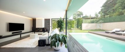 Modern living room overlooking the garden and swimming pool 