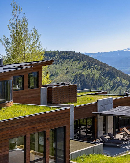 Exterior of Harvest Ridge home with manicured green grass with mountain views.