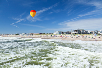 A hot air balloon flying above an ocean beach