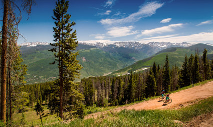 Two cyclists bike through Vail’s trails , one of the best things to do in Vail in summer.