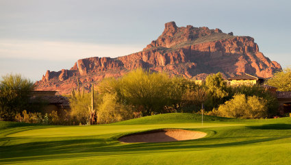 The red rocks of Scottsdale are visible from a green golf course, one of the best vacation spots for couples.