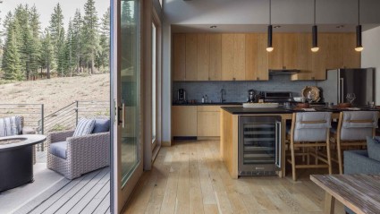 A modern kitchen opens into an outdoor deck of a second home in Truckee