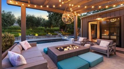 Outdoor gathering space in the evening with comfortable seating and a fire pit