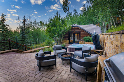 Exterior image of a mountain patio with a fire pit and hot tub.