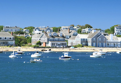 Sailboats and yachts rest near the shore in Nantucket, considered one of the best east coast beach towns.