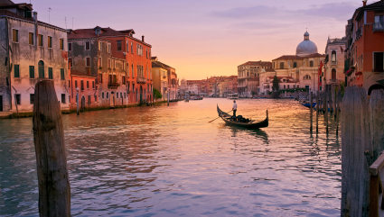 A loan gondola floats in the canal of Venice, one of the best vacation spots for couples. 