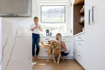 Two women and a golden retriever in the kitchen of their second home