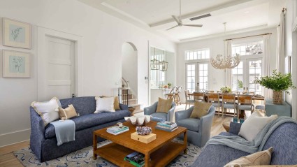 A cozy living room with stylish blue couches and a matching blue rug, creating a serene and inviting atmosphere