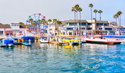 The harbor lined with colorful boats and a ferris wheel.