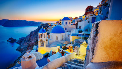Tightly packed white buildings cover the cliff of Santorini, one of the best vacation spots for couples. 
