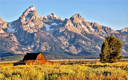 A barn glows under the Tetons at sunset, a breathtaking view in Jackson Hole, one of the top places to visit in the US.