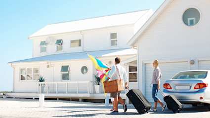 A family walks towards a beach house.