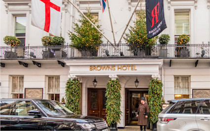 The entrance to Brown's Hotel, one of the best hotels in London, is shown in a daytime shot with cars parked nearby.