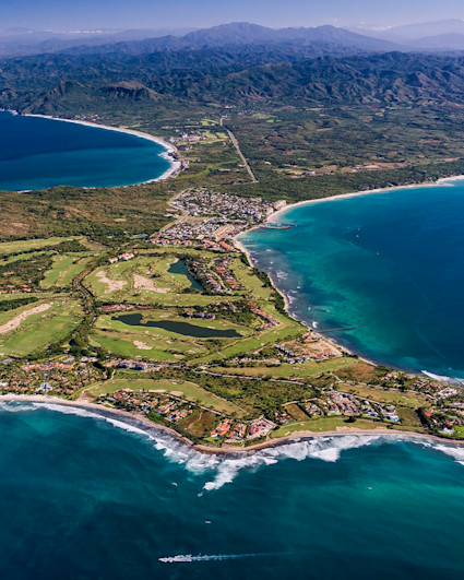 Aerial view of Punta de Mita peninsula and coast with mountains in the background.