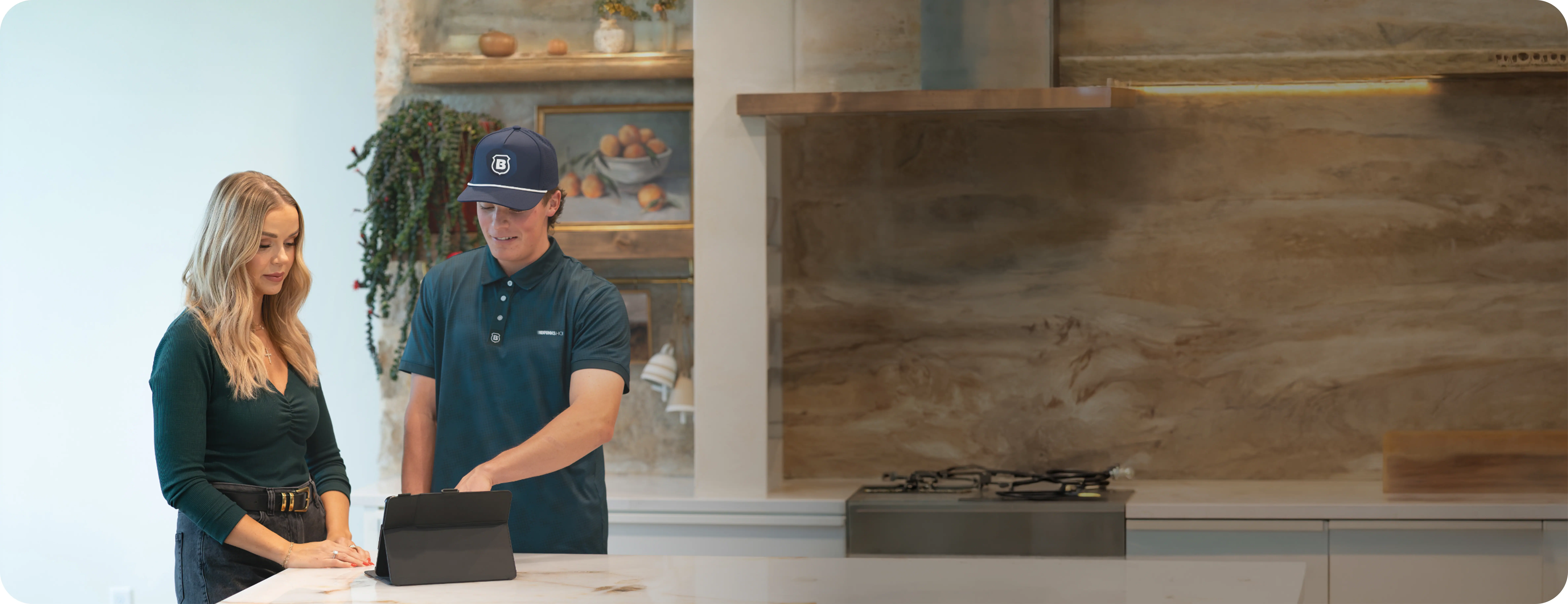 Brinks Home technician walking a homeowner through her smart home security options at the kitchen counter