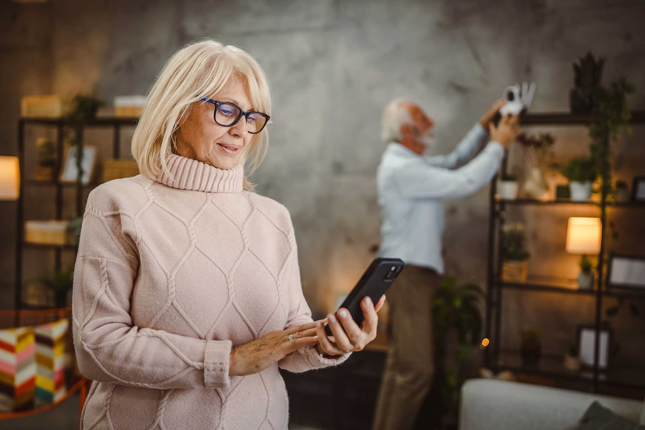 Older adults checking their home security panel.
