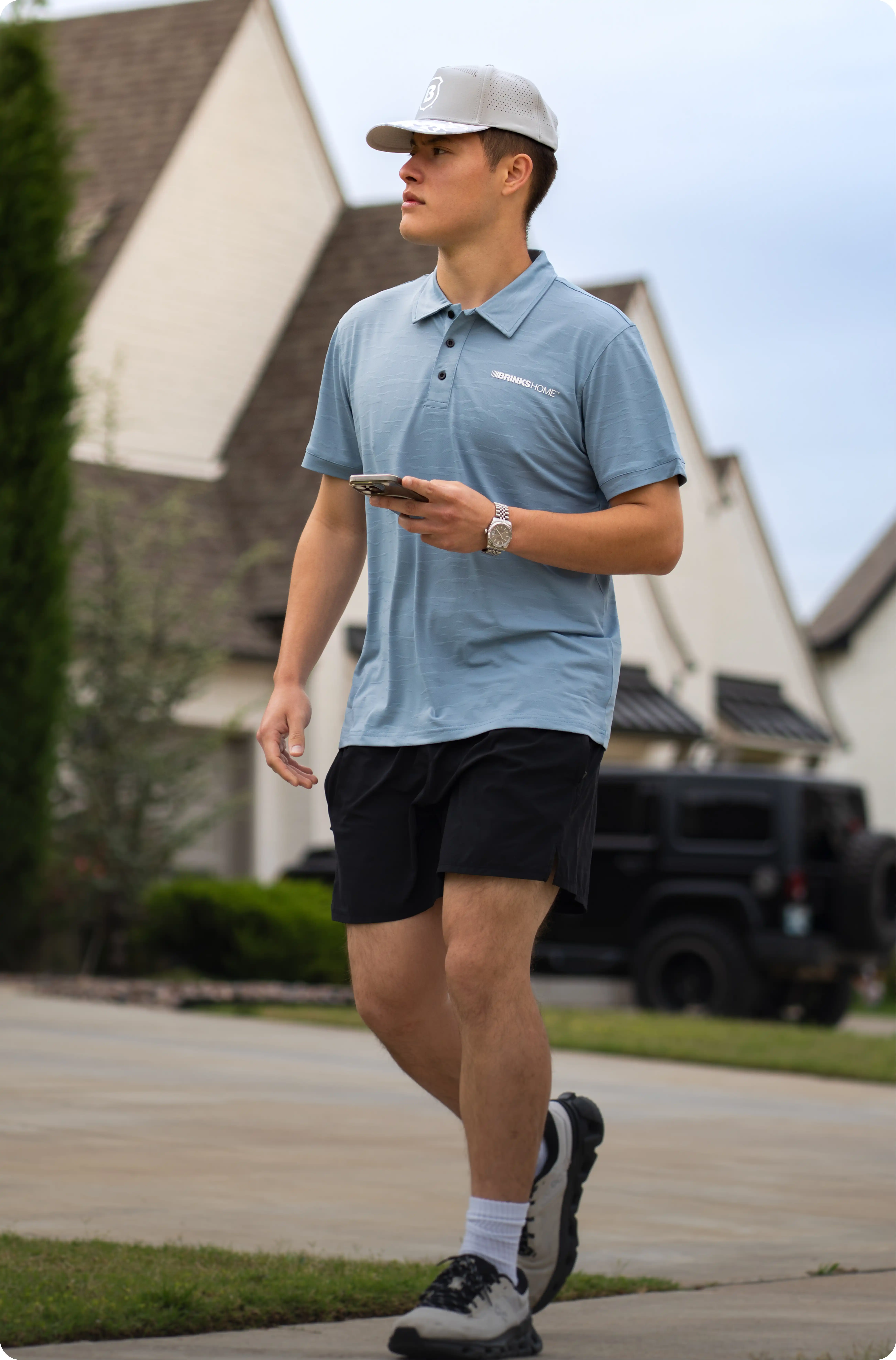 Brinks Home Sales Representative walking through a neighborhood in a branded uniform