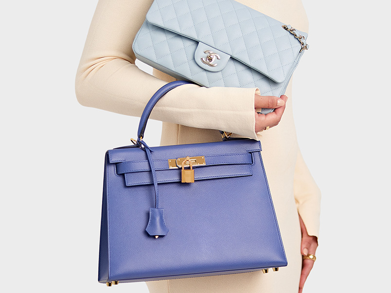 Woman holding Chanel and Hermes handbags