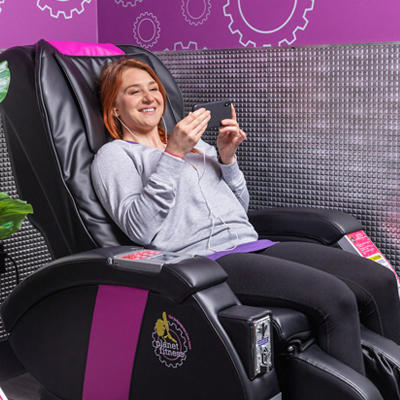 woman relaxing on a Planet Fitness massage chair