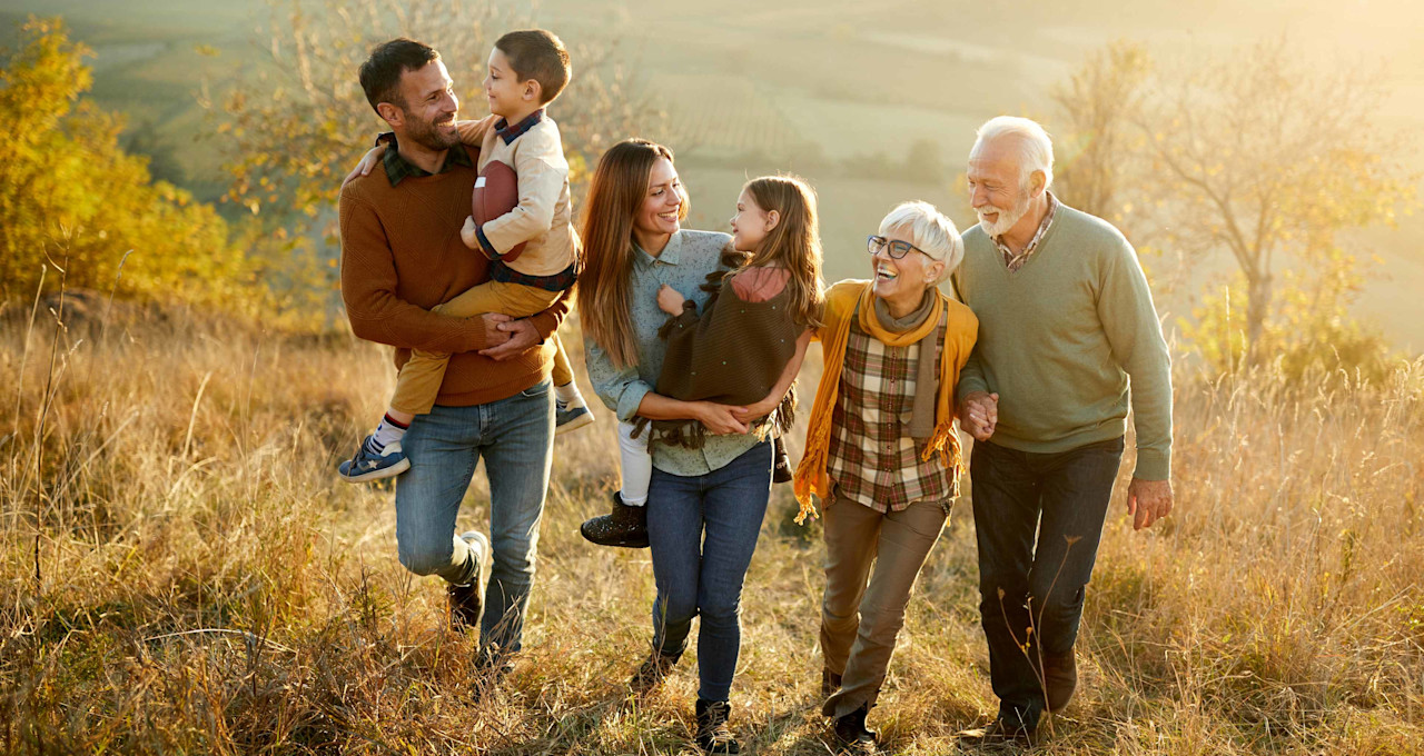 Familie mit drei Generationen auf einem herbstlichen Feld