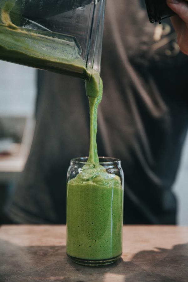 Pouring a green smoothie
