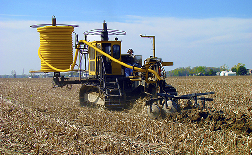 A farmer or earthworks contractor uses the WM-Drain solution to lay drainage tile in their field.
