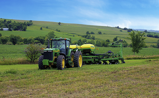 A farmer with a John Deere tractor and planter uses Trimble's TrueGuide implement guidance system to add precision to their planting operations.