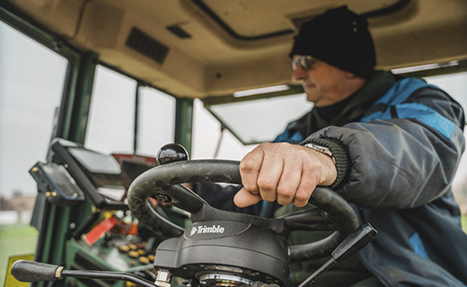 A farmer uses Trimble's Autopilot motor drive system to add precision to their farming activities.