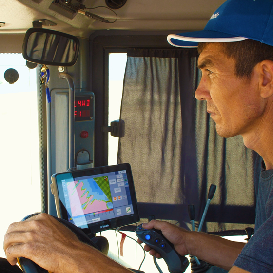 A farmer or earthworks contractor uses the Trimble TMX-2050 display for water management activities.