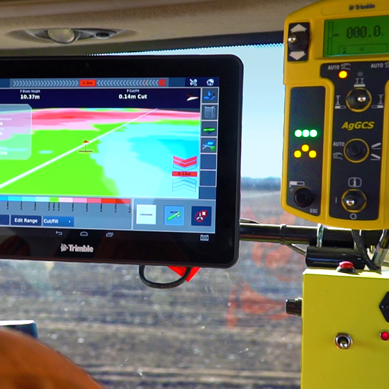 A farmer or earthworks contractor uses Trimble's TMX-2050 display to guide their drainage project.