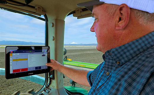 A farmer uses the Trimble GFX-1260 display to manage their land and seedbed preparation.