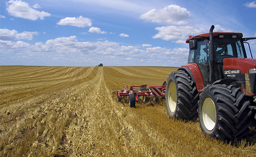 A farmer uses Trimble's EZ-Steer system on their Case-IH tractor add precision while farming.